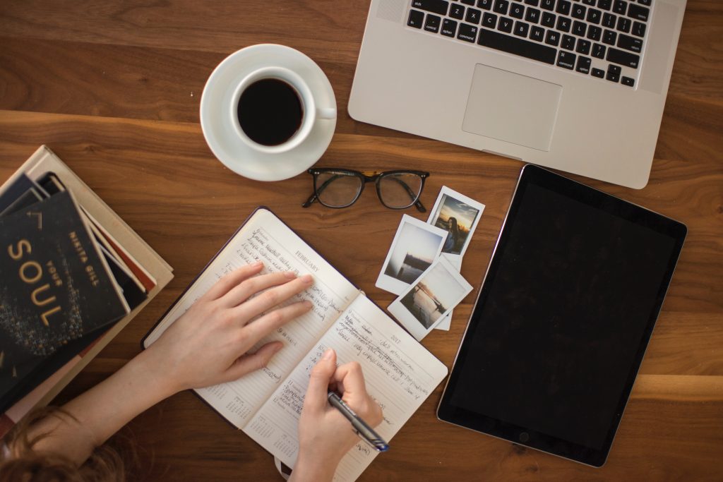 writing on desk with coffee and computer