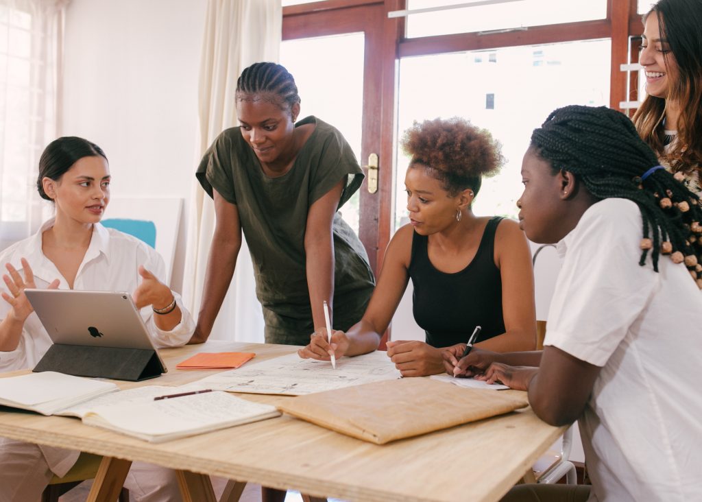 Group standing over desk doing work